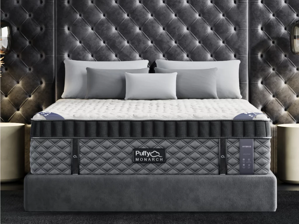 Puffy Monarch Hybrid mattress featuring luxury-plush design, cooling comfort, and back pain relief, set against a stylish tufted backdrop with decorative pillows.