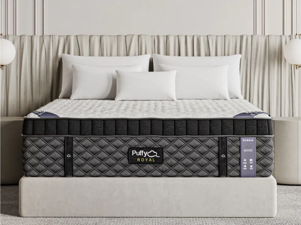 Puffy Royal Hybrid mattress with ultra-plush design, featuring a quilted cover, displayed on a modern bed frame with decorative pillows and soft backdrop.