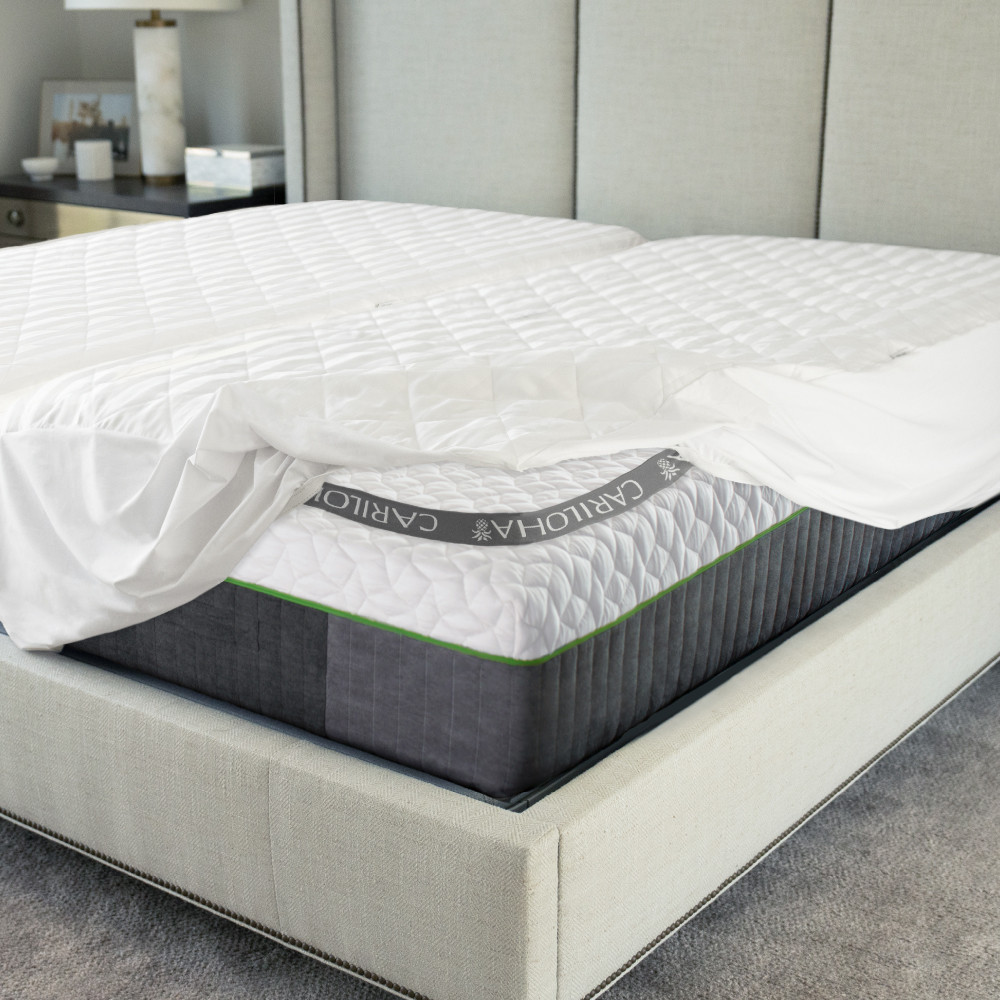 Cariloha Quilted Mattress Protector on a bed, showcasing its bamboo material, waterproof features, and cloudlike comfort, with a stylish gray and white design.