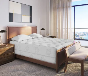 Rowan Hybrid mattress displayed in a modern bedroom setting with a wooden bed frame, plush bedding, and a scenic window view.