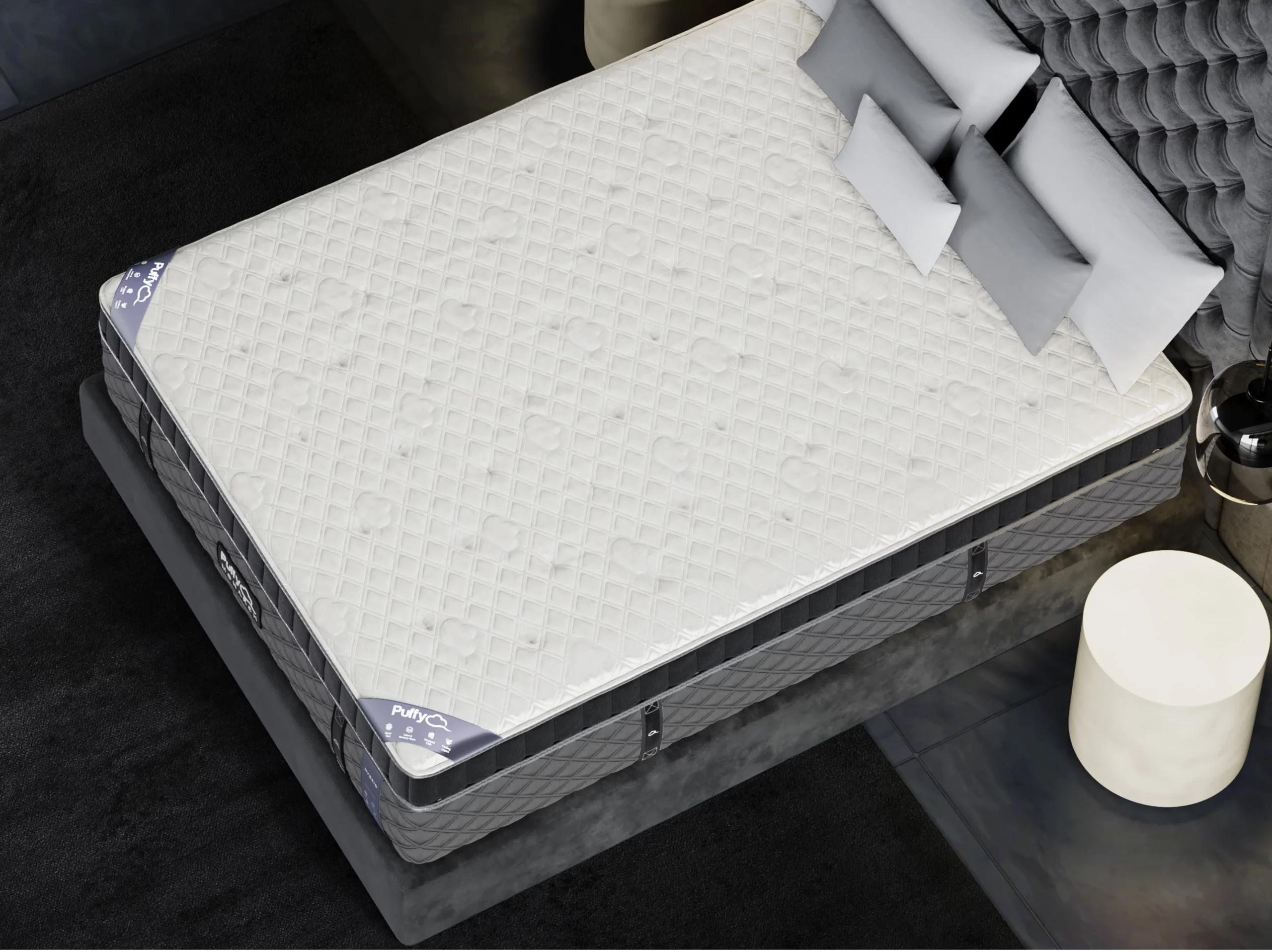 Puffy Monarch Hybrid 2.0 mattress with quilted cover and supportive layers, displayed on a stylish bed setting, featuring gray pillows and modern decor.